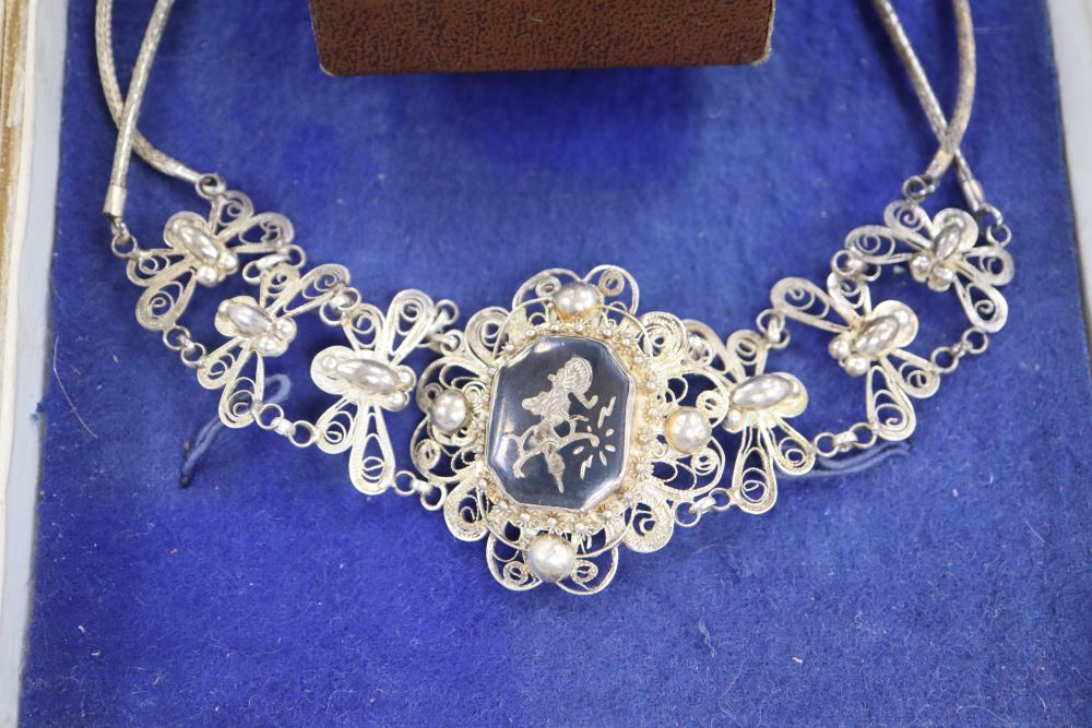 A Siamese filigree white metal and niello necklace and a marcasite brooch.